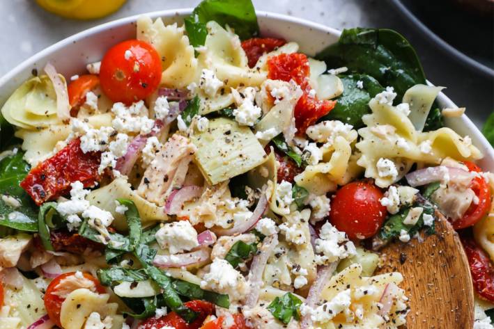 a bowl of pasta salad with veggies and tuna fish