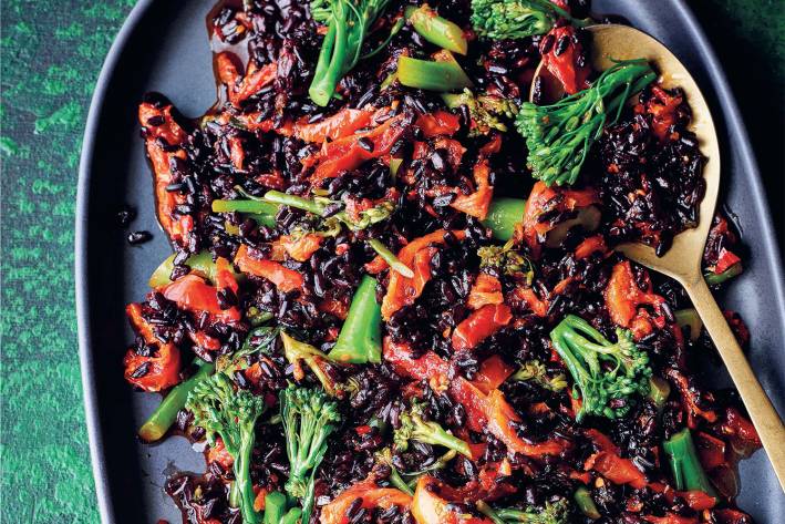 a plate of spiced black rice with vegetables