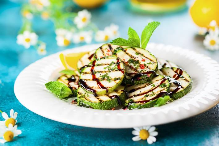 a plate of grilled zucchini drizzled in balsamic