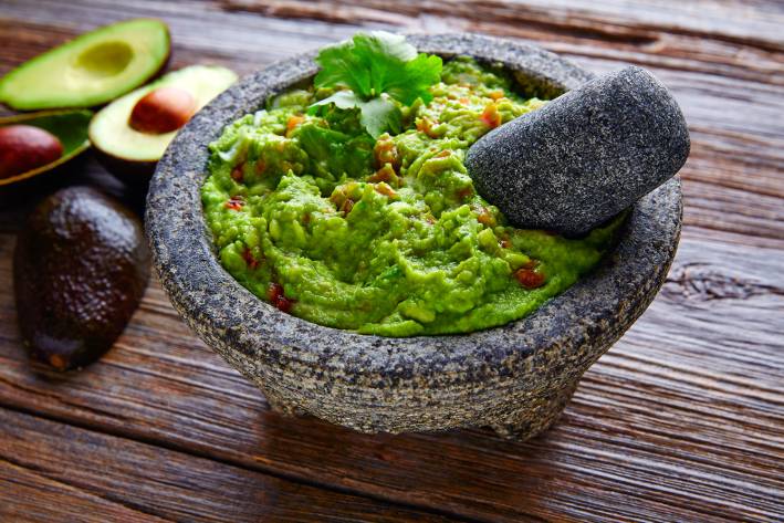 guacamole sauce served in a traditional stone bowl