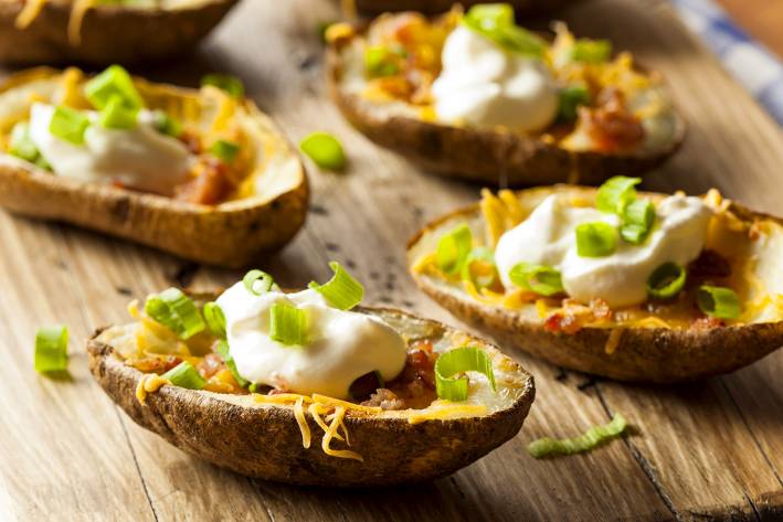 baked potato skins with cheese, bacon, sour cream, and scallions