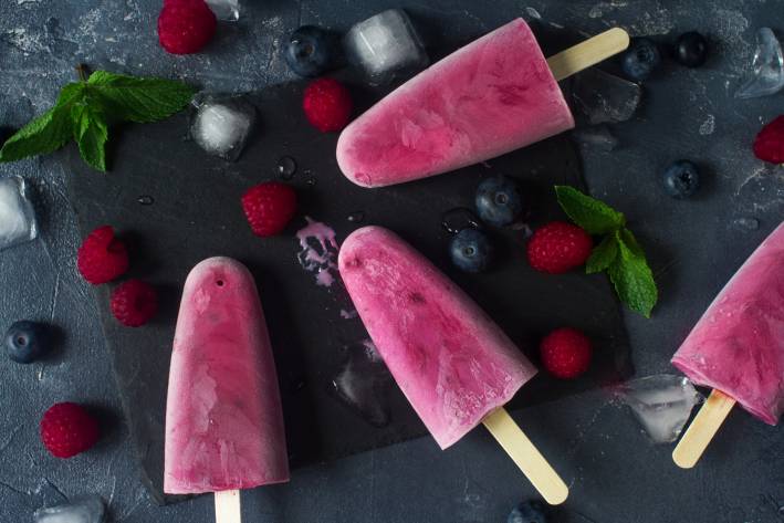 Goat milk yogurt pops, surrounded by berries and ice