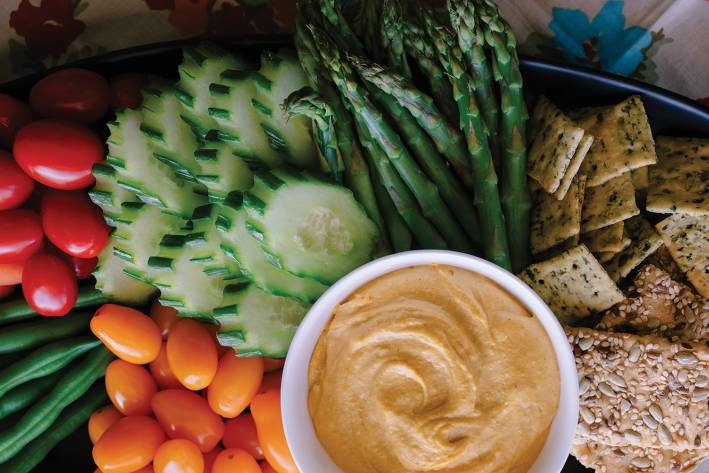 Sweet Potato Cashew Dip on a platter with veggies and crackers.