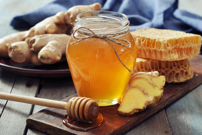 a jar of honey and fresh sliced ginger root