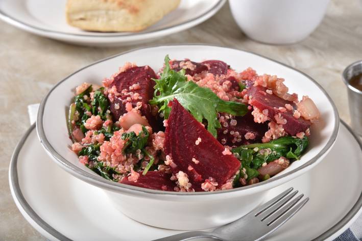 a bowl of quinoa, beets, and leafy greens