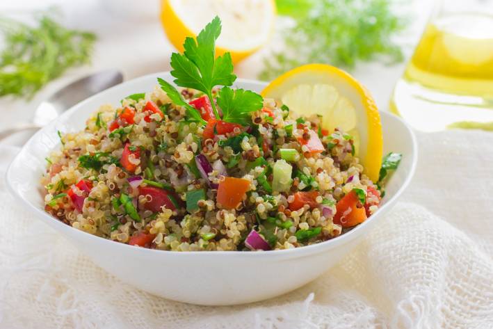 a bowl of buckwheat, diced tomatoes, onions, and spices