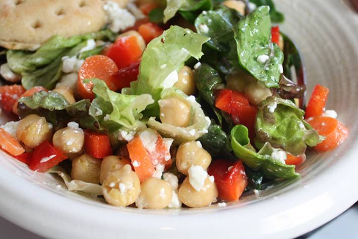 a tossed salad with greens and beans