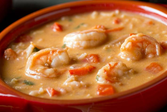 a bowl of creamy coconut soup with shrimp and spices