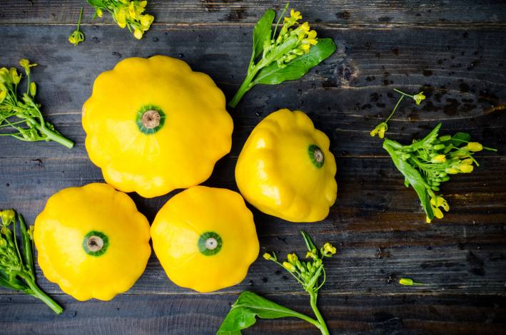 Yellow patty pan squash on wooden background.
