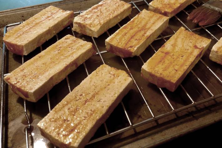 slices of tofu on the grill with a little oil
