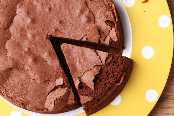 slicing into a gluten-free chocolate cake