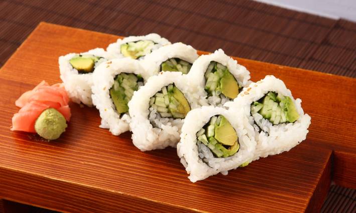 vegan maki rolls on a board with ginger and wasabi