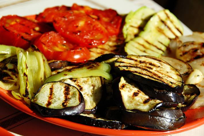 a platter of grilled squash, tomato, and eggplant