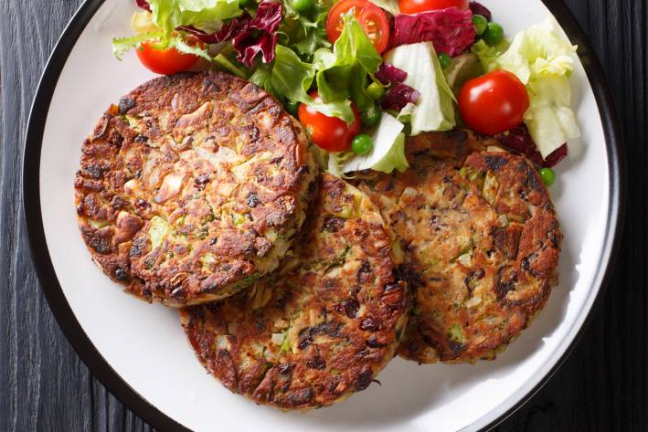 a platter of vegetarian patties with a side salad