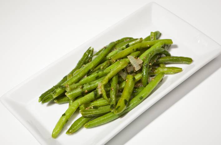 Green beans on a rectangular white plate. 