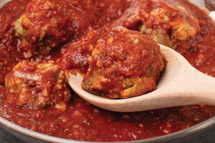 an eggplant meatball covered in red sauce