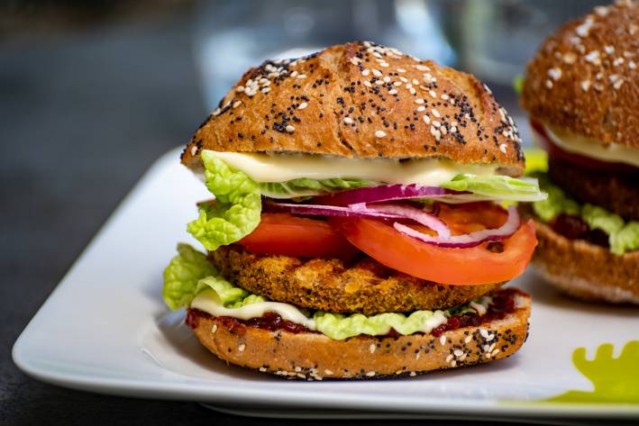 a plate with two stacked burgers with vegetarian patties