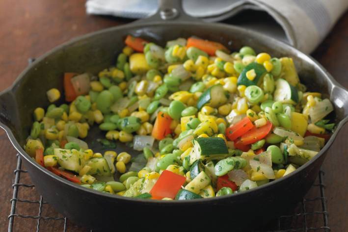 a skillet of sautéed corn and diced vegetables