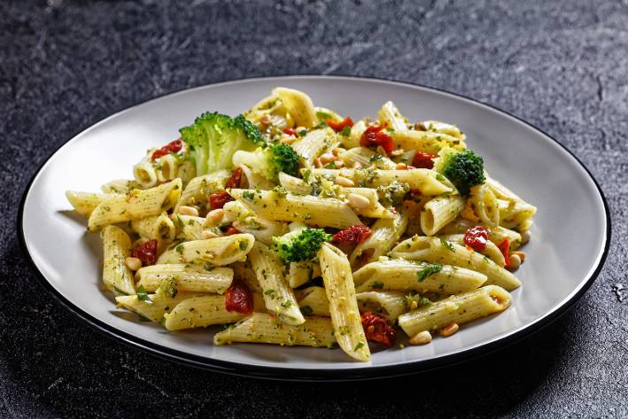 a plate of penne with broccoli and sundried tomatoes
