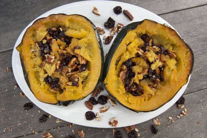 A plate of acorn squash stuffed with berries and pecans
