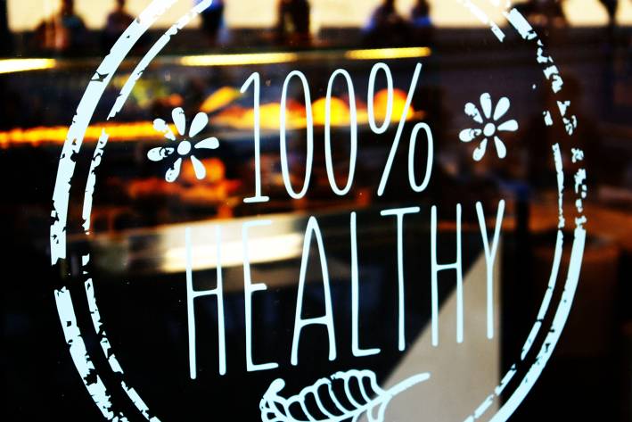 a restaurant with a sticker in the window that says "100% healthy"
