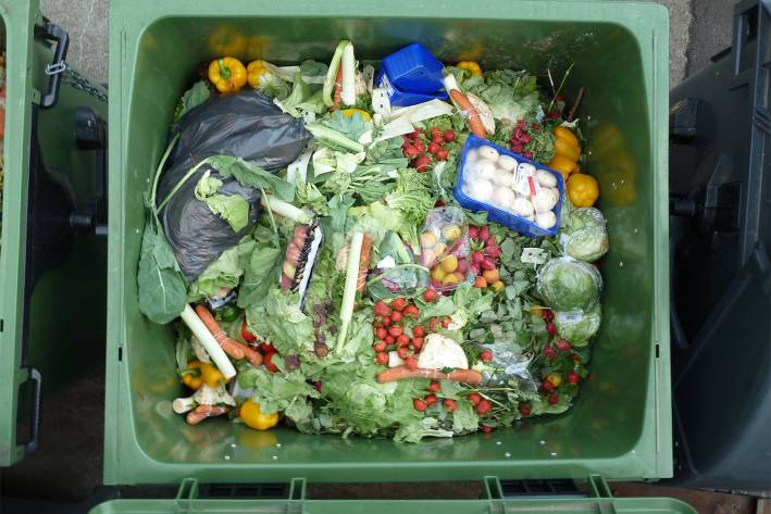 a commercial garbage container full of usable food from the store