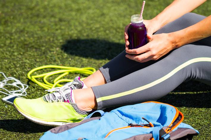 A runner taking a break to drink her beetroot juice