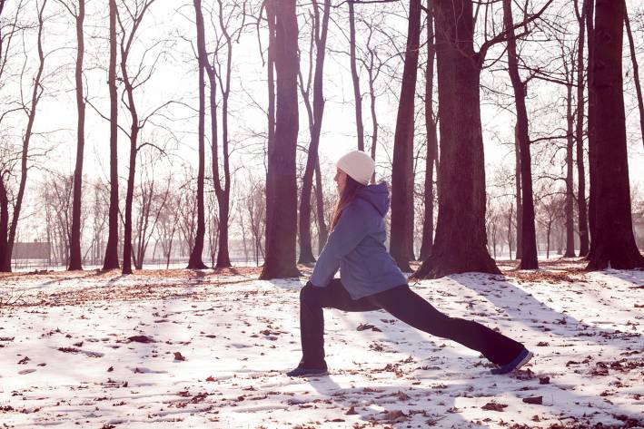 a woman stretching in the park in winter