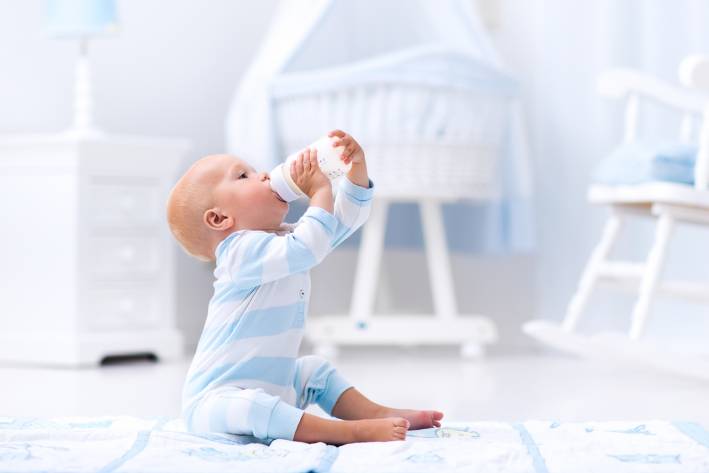 A baby boy drinking formula from a bottle