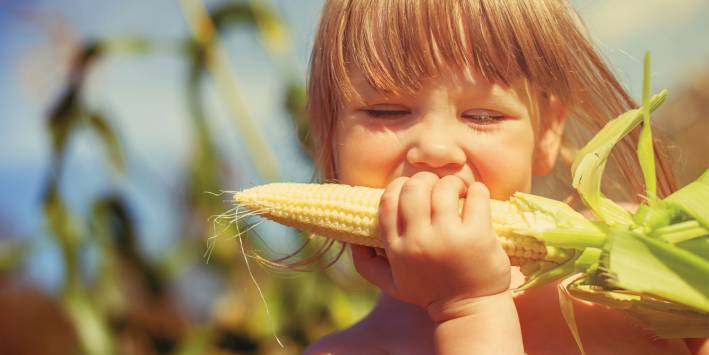 Girl Eating Organic Corn
