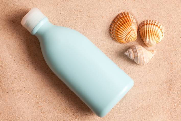 Seashells and water bottle on the sand