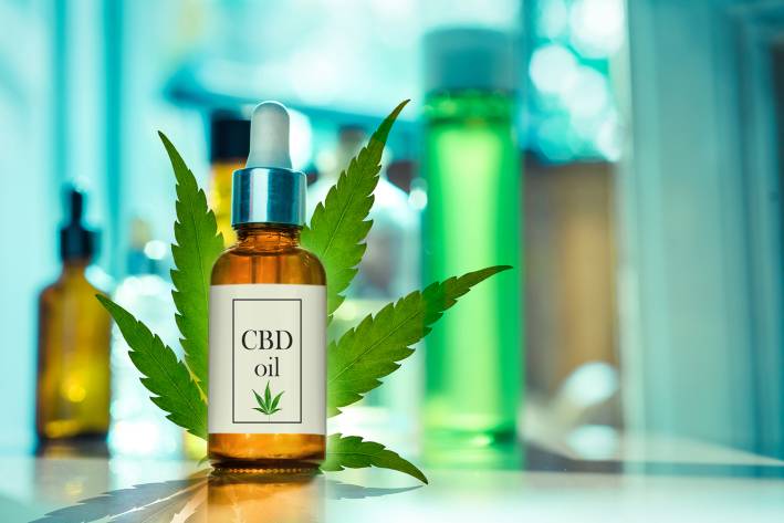 Glass bottle CBD OIL, tincture with laboratory for the production of CBD oil.