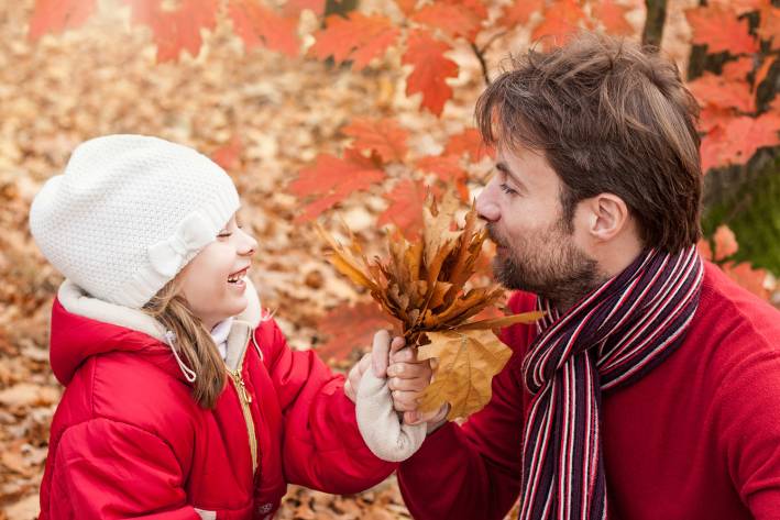 a man and his daughter enjoying autumn in the park