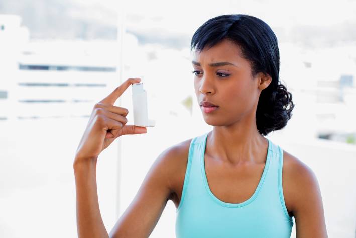 A woman wondering about her asthma inhaler