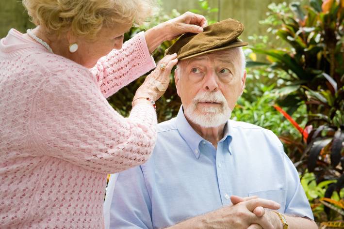A senior woman putting a hat on her husband