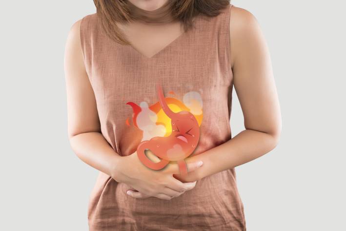 a woman in pain due to a burning cartoon stomach