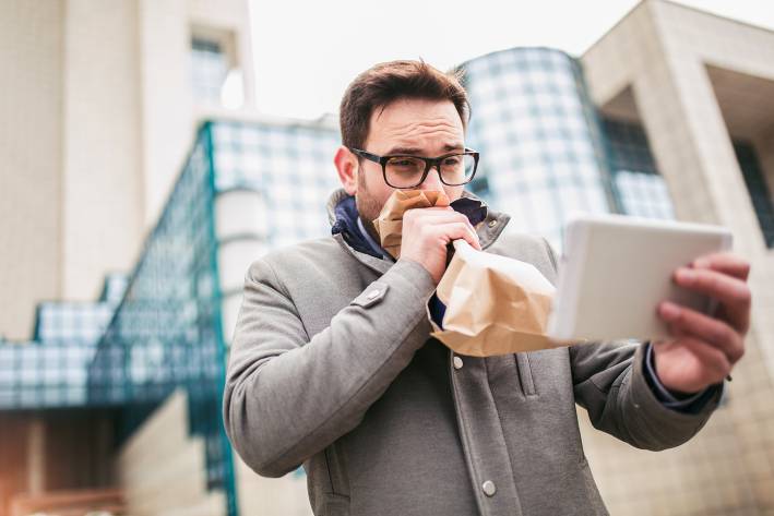 a man breathing into a paper bag while he reads the news