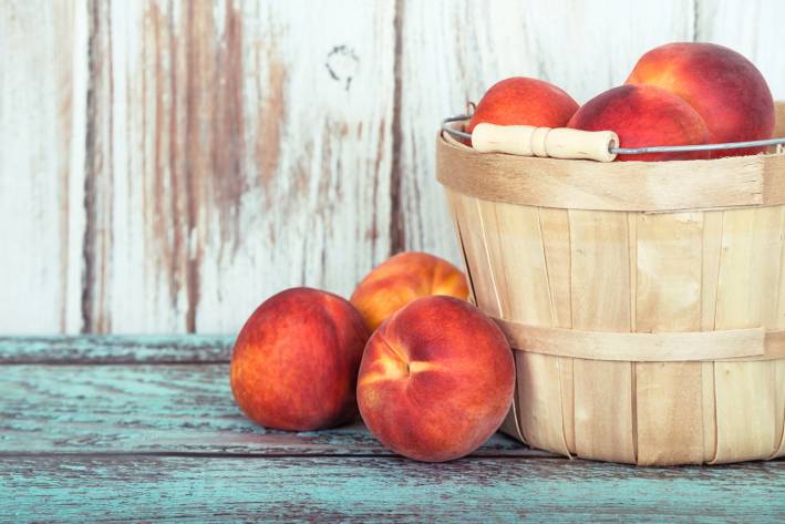 A basket of fresh organic peaches.