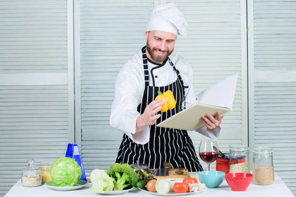 a cook reading kitchen tips from a guidebook