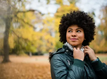 Candid shot of a young woman outdoors in autumn.
