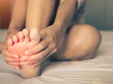 A woman massaging pain in his foot