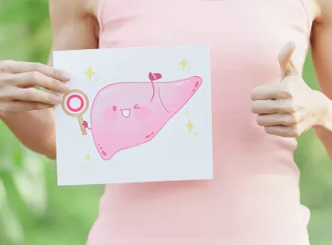 a woman holding a cartoon illustration of a happy, healthy liver