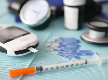 a diabetes testing strip and syringe
