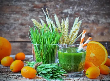 A green smoothie with wheatgrass and oranges