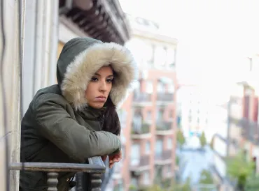 a depressed woman looking out at the city