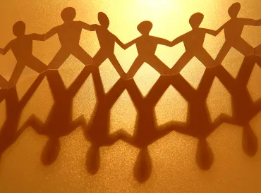 Paper figurines holding hands