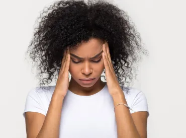 a woman with a serious headache rubbing her temples