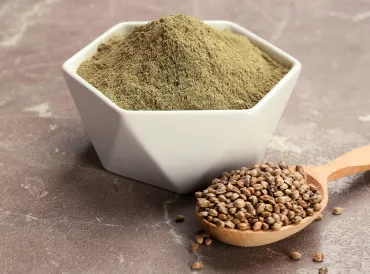 a spoon full of hemp seeds, and a bowl of protein powder