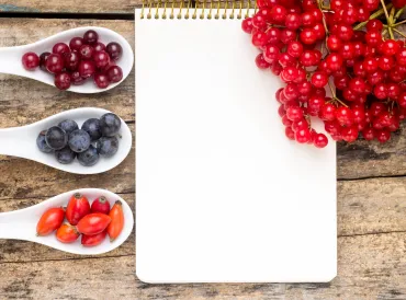 wild berries on wooden table with notebook 