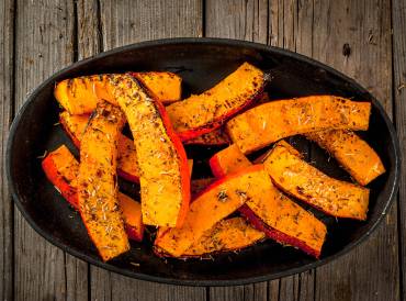 a bowl of seasoned pumpkin wedges